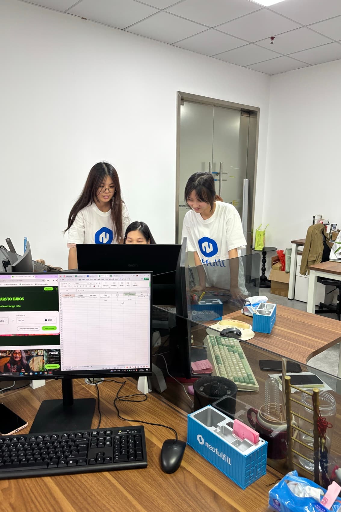 Two Neofulfill team members working an order together on screen in the Shenzhen office.